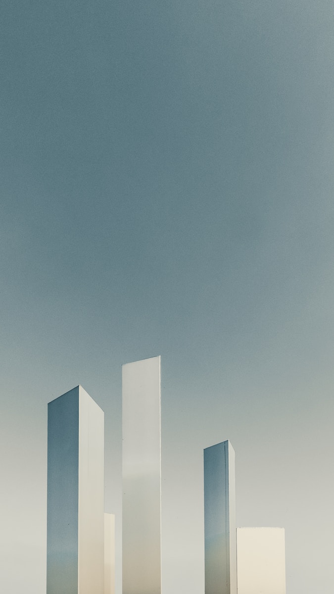 Photo by ot design a group of tall white buildings sitting next to each other